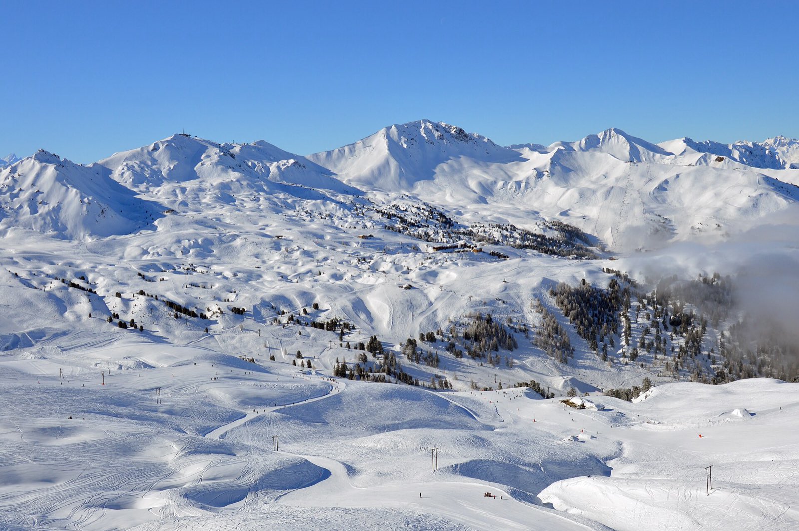 Besneeuwd skigebied La Plagne met bergtoppen in de verte