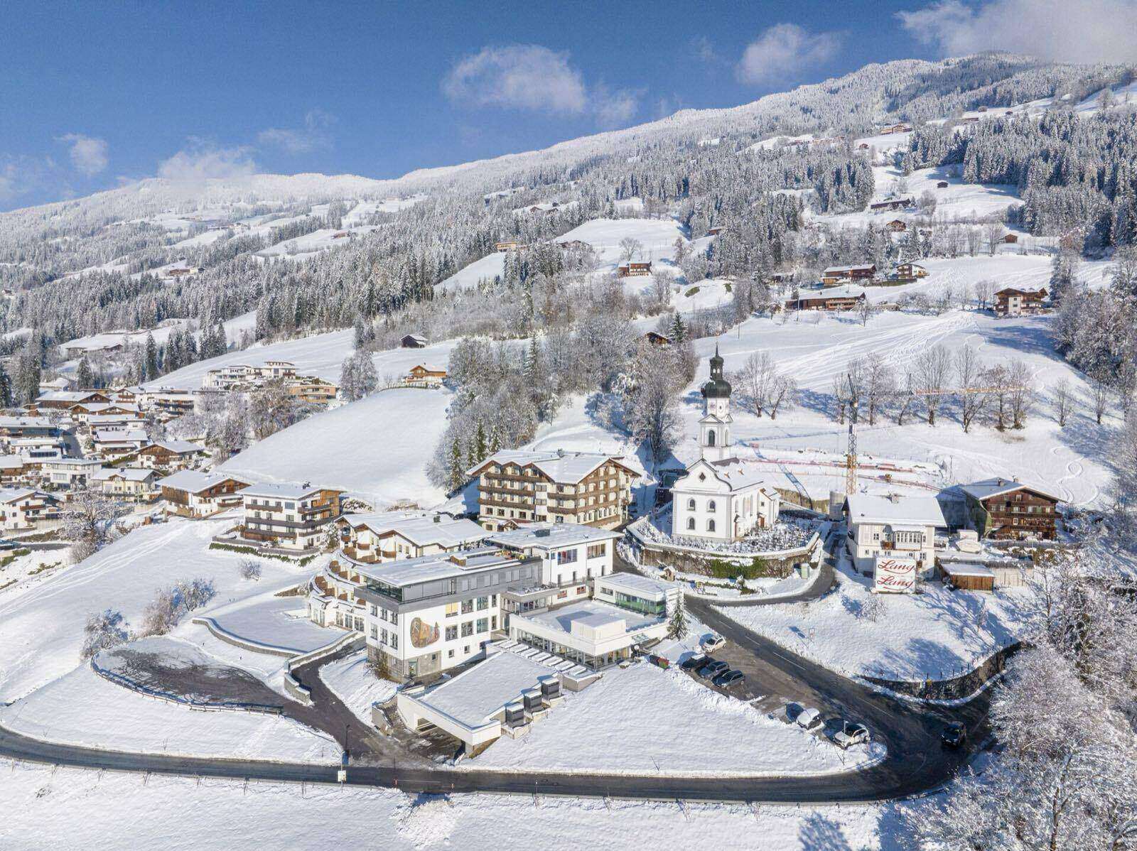 Besneeuwd dorp in het Zillertal met kerk, gezien van boven